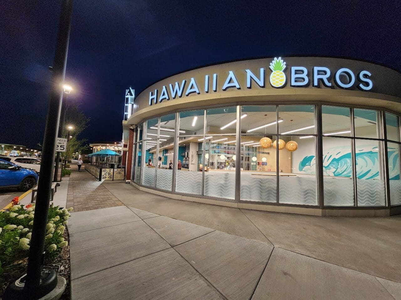 the exterior of a Hawaiian bros restaurant. It's night and the restaurant is lit up.