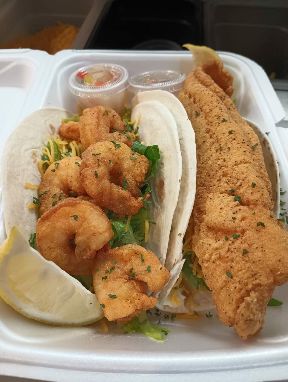 a to go box with fried fish and shrimp
