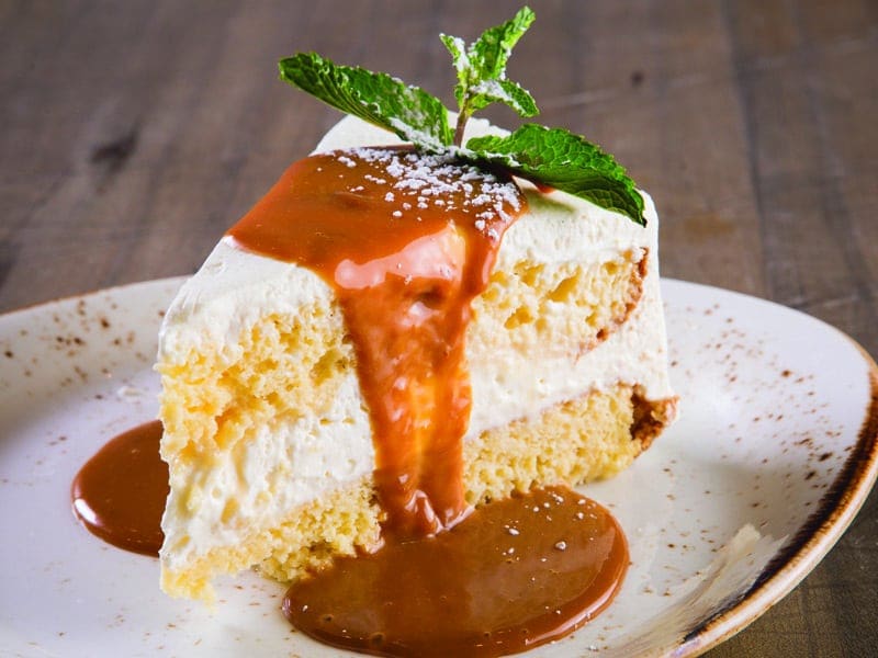a slice of tres leches cake on a white plate