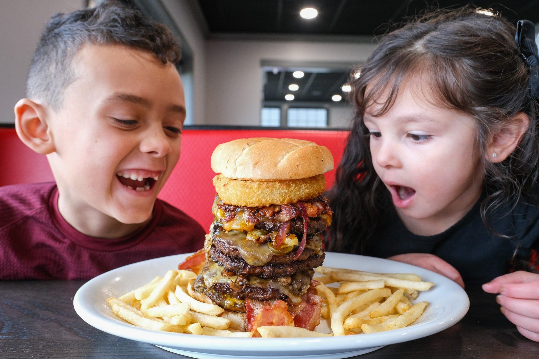 two young children looking at a giant burger at copps pizza