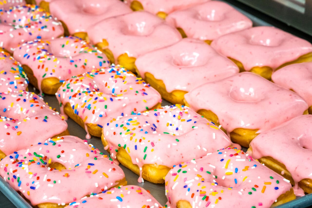 a pan of pink square donuts