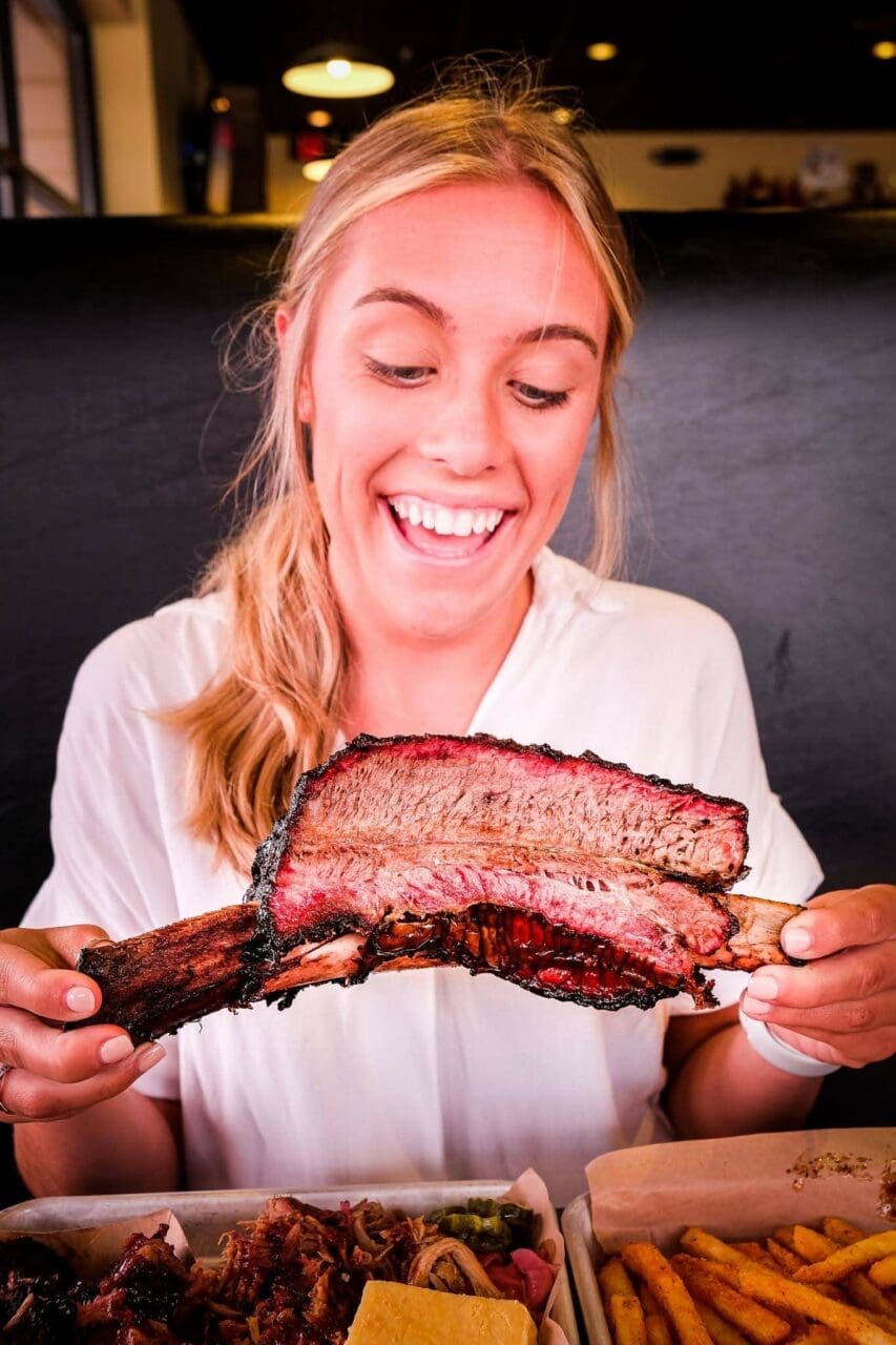 a women holding a beef rib
