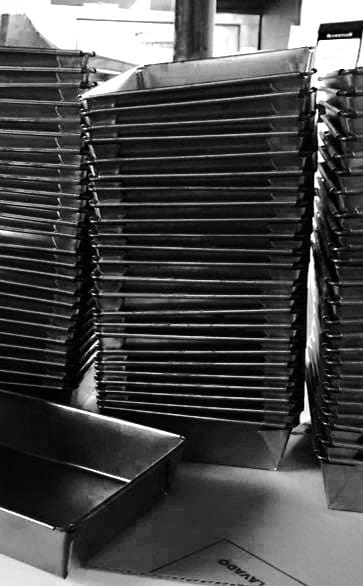 a stack of blue steel Detroit deep dish pans in black and white.