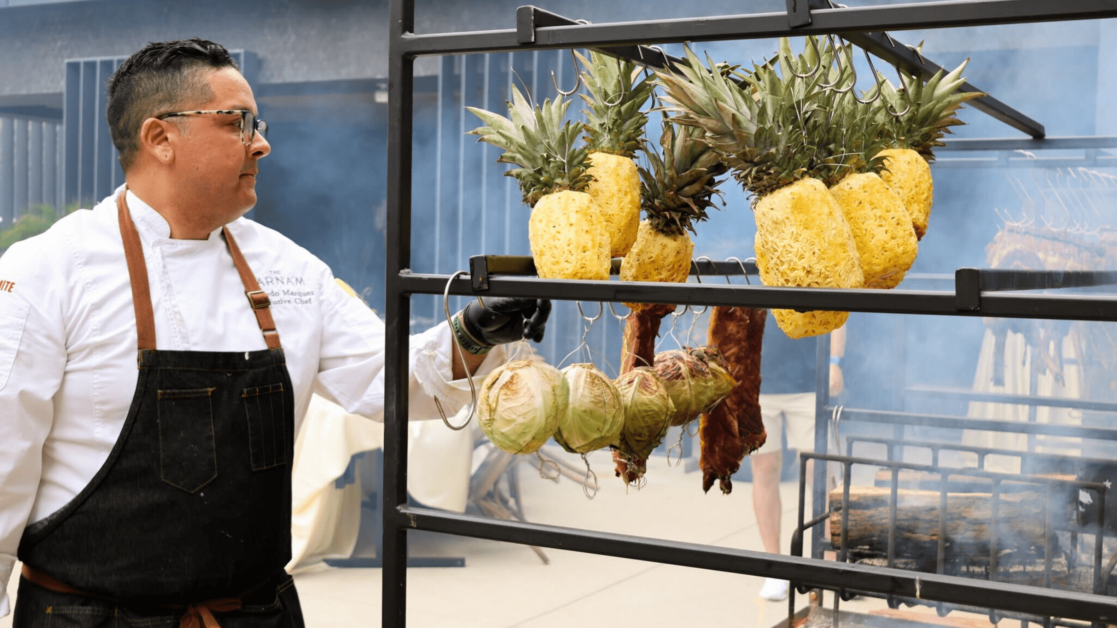 Chef Eduardo Marquez tending live-fire pineapples and vegetables at Fire to Table, Farnam Hotel Omaha