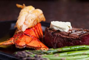a picture of a lobster, asparagus, and a steak