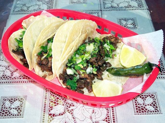 a plate of carne asada tacos in a red basket
